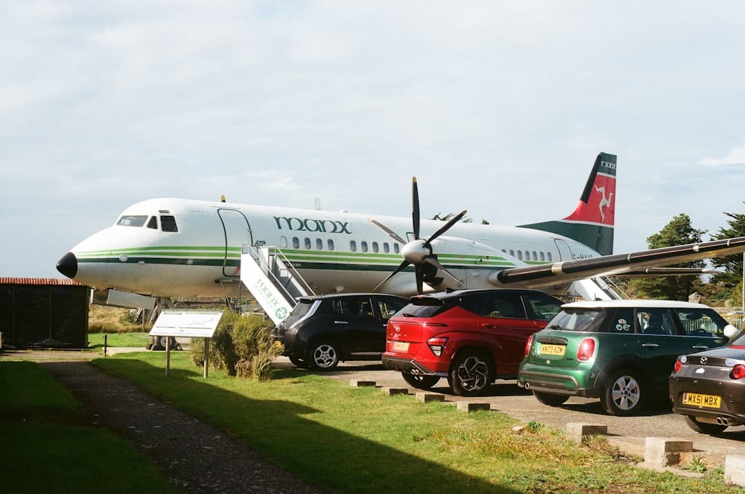Small airplane parked with cars nearby — Photo by Tanya Barrow on Unsplash