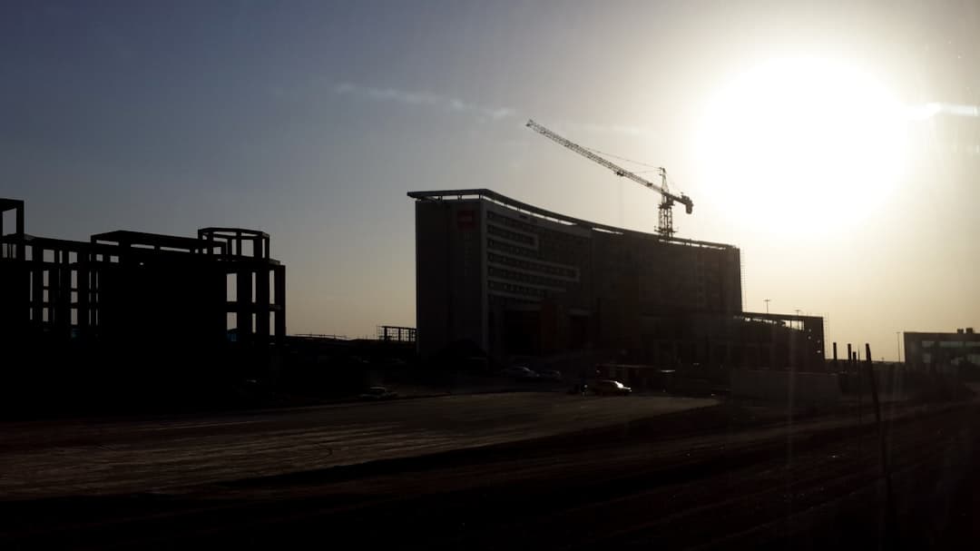 a building under construction with a crane in the background — Photo by Alireza Akhlaghi on Unsplash