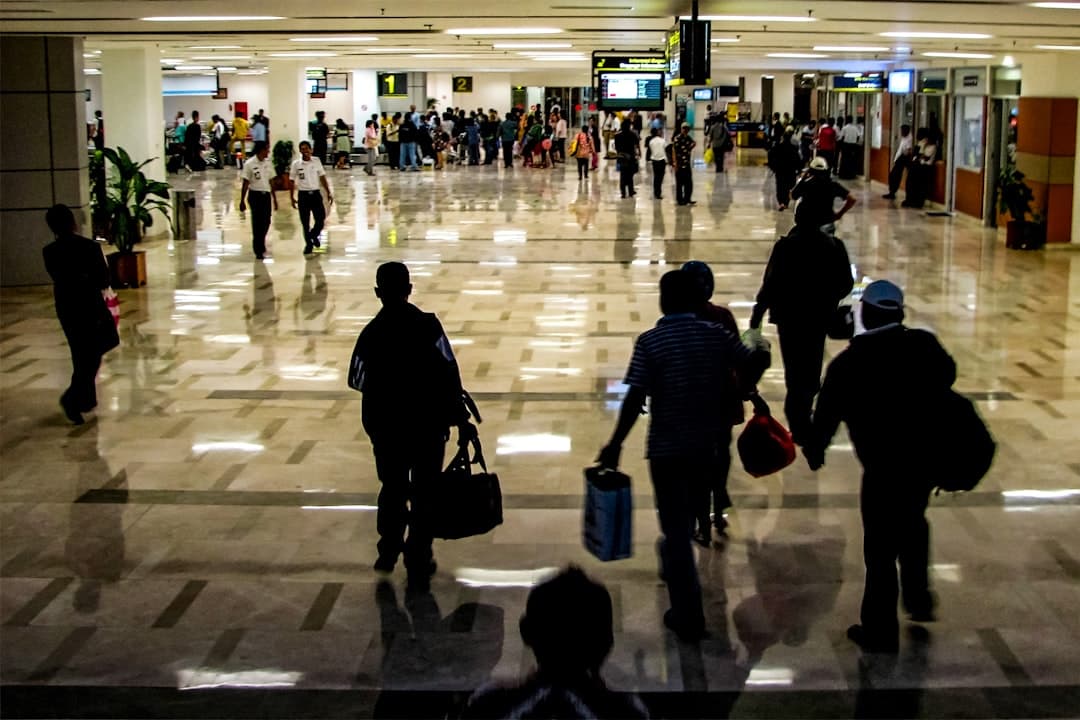 People are walking through a busy airport terminal. — Photo by motomoto sc on Unsplash