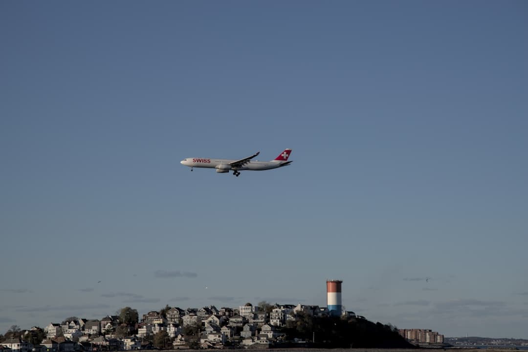An airplane is flying over a small island — Photo by Satish Dharmavarapu on Unsplash